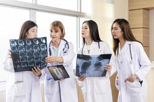 Senior doctor woman teaching doctor student woman. How to analyze the X-ray film. Radiology department photo