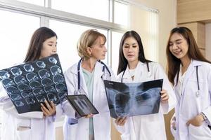 Senior doctor woman teaching doctor student woman. How to analyze the X-ray film. Radiology department photo