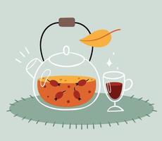 té de rosa mosqueta en una tetera transparente. una copa de vino caliente. bebida de otoño caliente.
