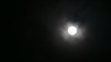 nuages se déplaçant à travers une pleine lune