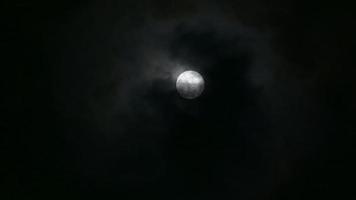 nuages se déplaçant à travers une pleine lune