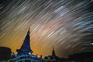 Star trails at Night above Pagoda silhouette in Thailand.