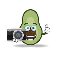 personaje de mascota de aguacate sosteniendo la cámara. ilustración vectorial vector