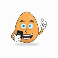 Egg mascot character holding a cellphone. vector illustration