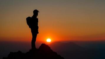 Mountaineer on the top of the mountain watching the fantastic sunset photo