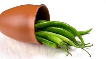 Fresh long Indian green chillies on wooden background. photo