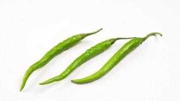 Fresh long Indian green chillies on wooden background. photo