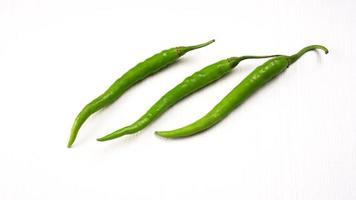 Fresh long Indian green chillies on wooden background. photo