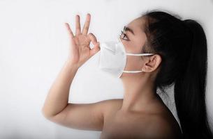 Close up of a woman putting on a respirator N95 mask to protect from airborne respiratory diseases as the flu covid-19 corona PM2.5 dust and smog photo