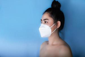 Close up of a woman putting on a respirator N95 mask to protect from airborne respiratory diseases as the flu covid-19 coronavirus ebola PM2.5 dust and smog photo