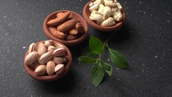 Pistachios or Pista nuts decorated with green leaves. plain background, top view.Flat lay. photo