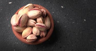 Pistachios or Pista nuts decorated with green leaves. plain background, top view.Flat lay. photo