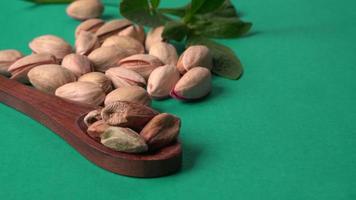 Pistachios or Pista nuts decorated with green leaves. plain background, top view.Flat lay. photo