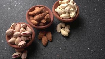 Pistachios or Pista nuts decorated with green leaves. plain background, top view.Flat lay. photo
