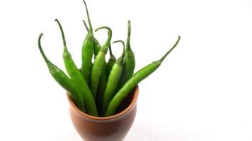 Fresh long Indian green chillies on wooden background. photo