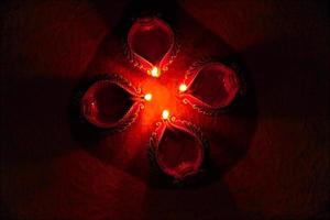 Happy Diwali - Diya lamps lit during Diwali celebration. Colourful and decorated lantern are lit in night on this occassion with flower rangoli, sweets and gifts. photo