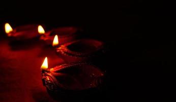 happy diwali - lámparas diya encendidas durante la celebración de diwali. linterna colorida y decorada se enciende en la noche en esta ocasión con rangoli de flores, dulces y regalos. foto