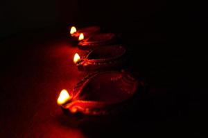 Happy Diwali - Diya lamps lit during Diwali celebration. Colourful and decorated lantern are lit in night on this occassion with flower rangoli, sweets and gifts. photo