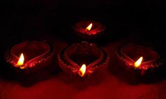 Happy Diwali - Diya lamps lit during Diwali celebration. Colourful and decorated lantern are lit in night on this occassion with flower rangoli, sweets and gifts. photo