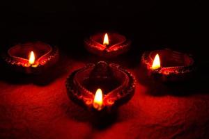 Happy Diwali - Diya lamps lit during Diwali celebration. Colourful and decorated lantern are lit in night on this occassion with flower rangoli, sweets and gifts. photo