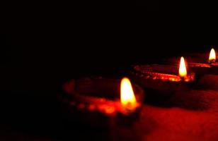 Happy Diwali - Diya lamps lit during Diwali celebration. Colourful and decorated lantern are lit in night on this occassion with flower rangoli, sweets and gifts. photo