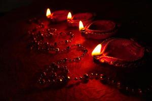 Happy Diwali - Diya lamps lit during Diwali celebration. Colourful and decorated lantern are lit in night on this occassion with flower rangoli, sweets and gifts. photo