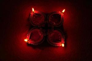 Happy Diwali - Diya lamps lit during Diwali celebration. Colourful and decorated lantern are lit in night on this occassion with flower rangoli, sweets and gifts. photo