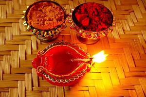 happy diwali - lámparas diya encendidas durante la celebración de diwali. linterna colorida y decorada se enciende en la noche en esta ocasión con rangoli de flores, dulces y regalos. foto