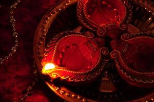 Happy Diwali - Diya lamps lit during Diwali celebration. Colourful and decorated lantern are lit in night on this occassion with flower rangoli, sweets and gifts. photo