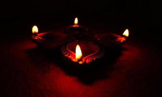 Happy Diwali - Diya lamps lit during Diwali celebration. Colourful and decorated lantern are lit in night on this occassion with flower rangoli, sweets and gifts. photo