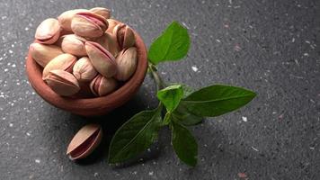 Pistachios or Pista nuts decorated with green leaves. plain background, top view.Flat lay. photo