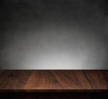 Wood table with dark concrete texture background photo