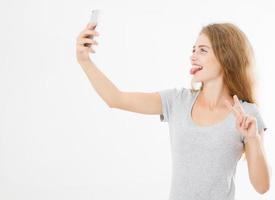 cute sexy woman in t shirt make selfie on front camera smartphone and show thoung isolated on white background,blank,copy space photo