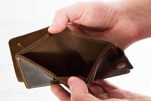 Empty wallet in hands. On a white background isolated - Bankruptcy photo