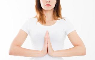 Close-up of hands of cute girl in white tshirt , meditating indoors, focus on arms in Namaste gesture. Asian medicine, yoga concept. Mock up. Copy space. Template. Blank. photo