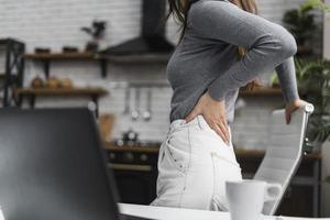 side view woman having backache while working from home