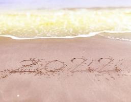 Happy new year , lettering numbers 2022 year on the sand photo