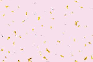 Confeti dorado plateado brillante aislado sobre fondo rosa. efecto de vacaciones foto