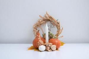 Autumn still life of pumpkins, dried flowers with a candle photo