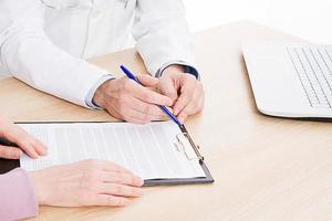 Doctor and patient are discussing something, just hands at the table, medical insurance. photo