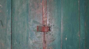 Architectural vintage background - old rusty metal padlock hanging on the wooden textured door. Focus at the padlock. photo