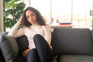 Latin woman sitting on sofa with lonely feeling photo