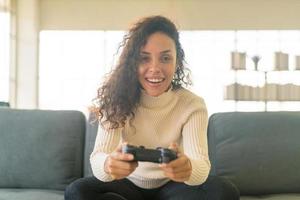 mujer laitina jugando videojuegos con las manos sosteniendo el joystick foto