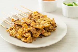 Pork satay with peanut sauce pickles which are cucumber slices and onions in vinegar photo