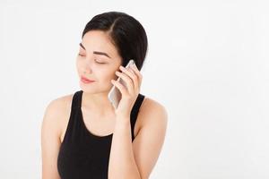 Sonriente mujer japonesa asiática mantenga blanco smartphone o teléfono móvil aislado sobre fondo blanco textura concepto publicitario. expresión facial positiva emoción humana. copie el espacio. foto