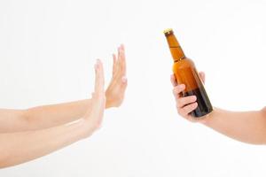 mano femenina rechazar una botella de cerveza aislado sobre fondo blanco concepto anti alcohol. copia espacio foto