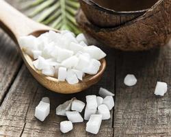 Dried sweet coconut cubes  in spoon photo