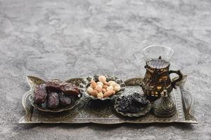 traditional turkish arabic tea glasses dates nuts metallic tray concrete backdrop