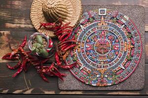decorative mexican symbol board near dried chili sombrero