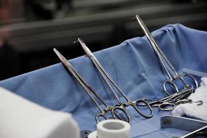 Close-up of scissors with thread and needle in an operating room. photo